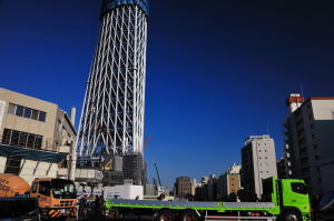 東京スカイツリーと工事現場から出てくるトラックたち