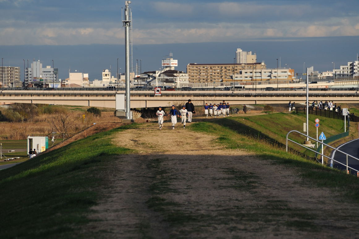 足立区千住大川町辺りの土手を走る野球少女たち