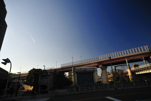 枕橋から隅田川への水門を見ると飛行機雲が