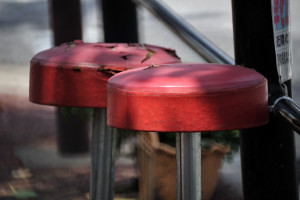 桜の木の下に置かれた赤い丸椅子２つ